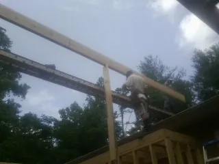 Carpenter setting a ridge beam over a new addition frame — Ice Dam Removal by Roofing Brothers in Cooleemee