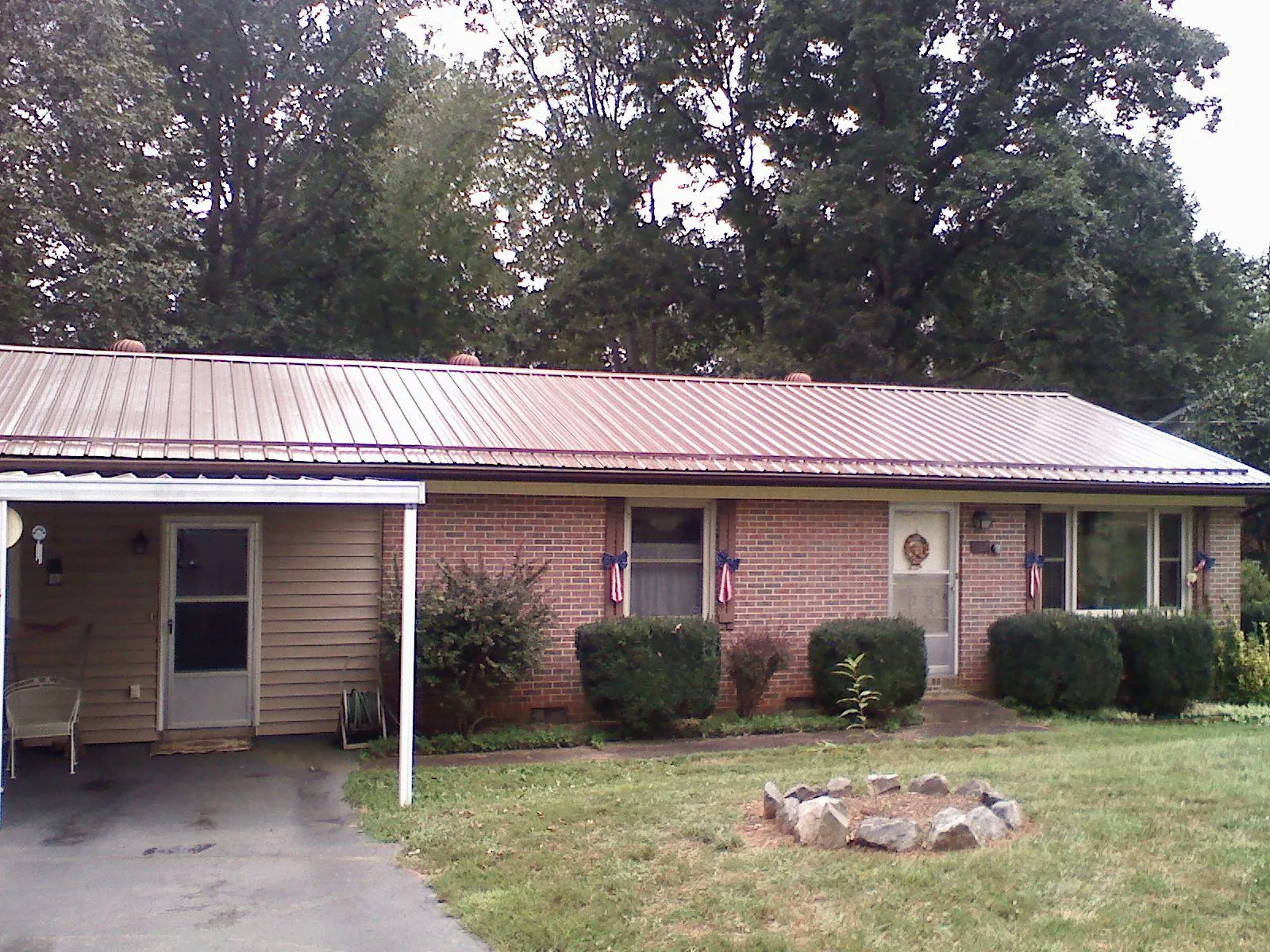 Bronze metal roof and carport on a brick ranch home — Roof Repair work by our crew in Cooleemee